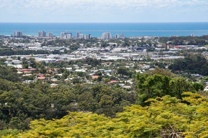 A View of a City From a Hill With Trees in the Foreground and the Ocean in the Background — Whirly Bird King in Sunshine Coast, QLD