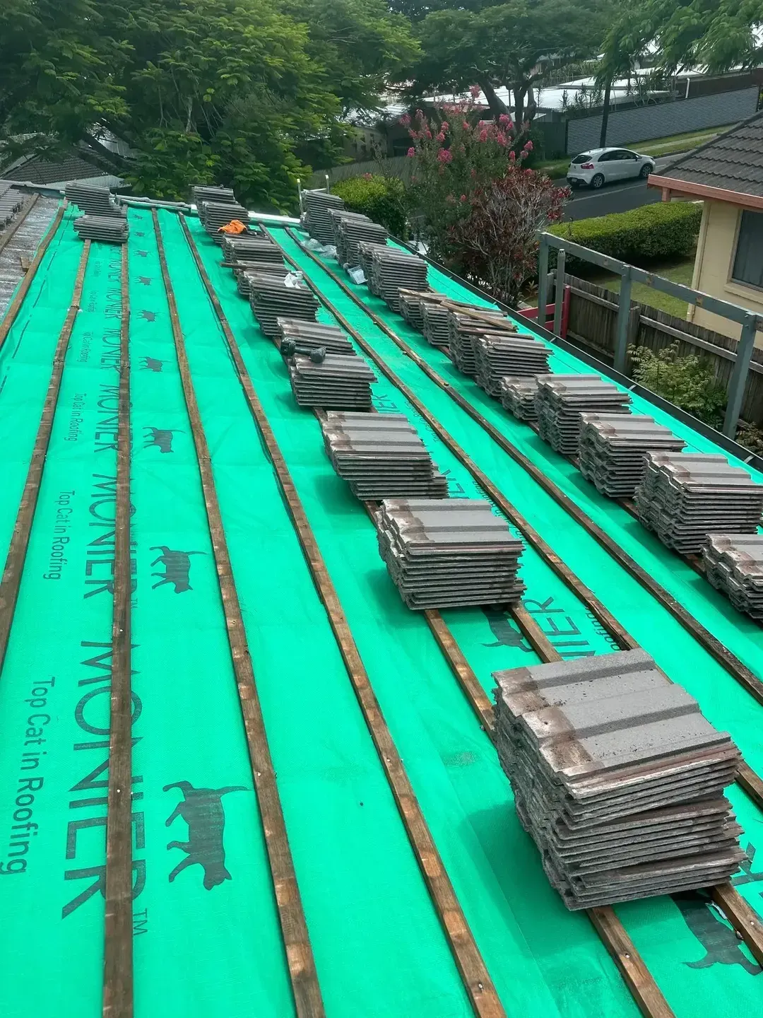 Roof under construction with stacks of tiles on green underlayment. — Whirly Bird King in Chermside, QLD