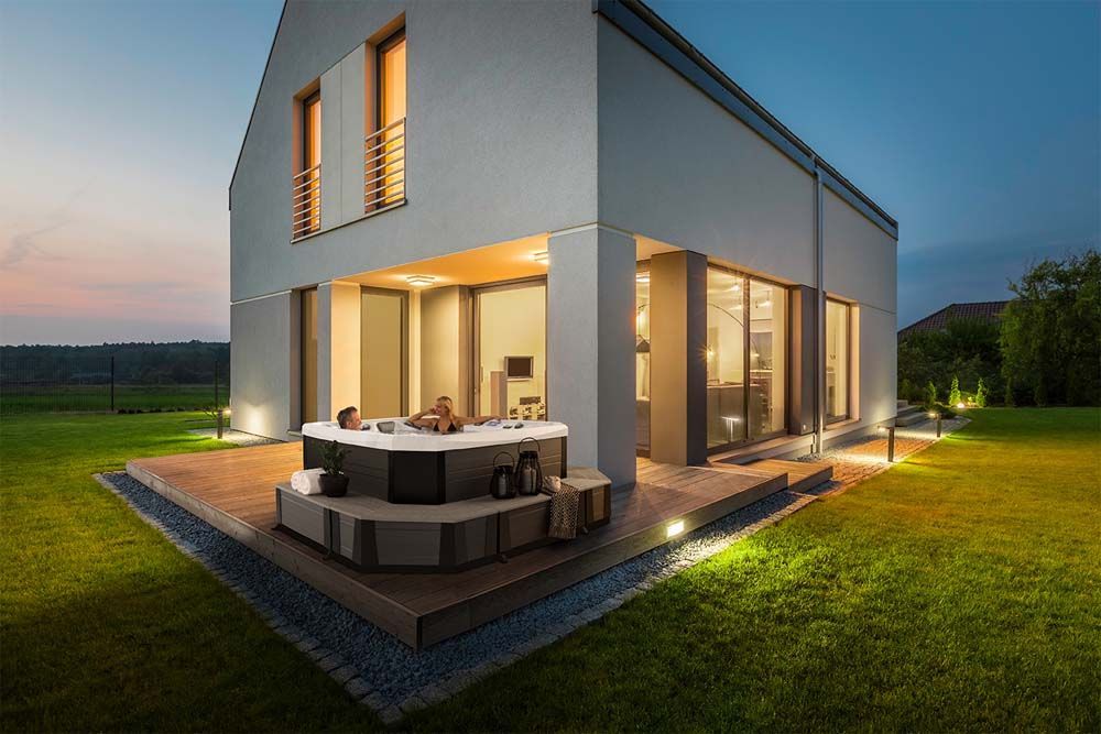 A modern house with a hot tub in the backyard.