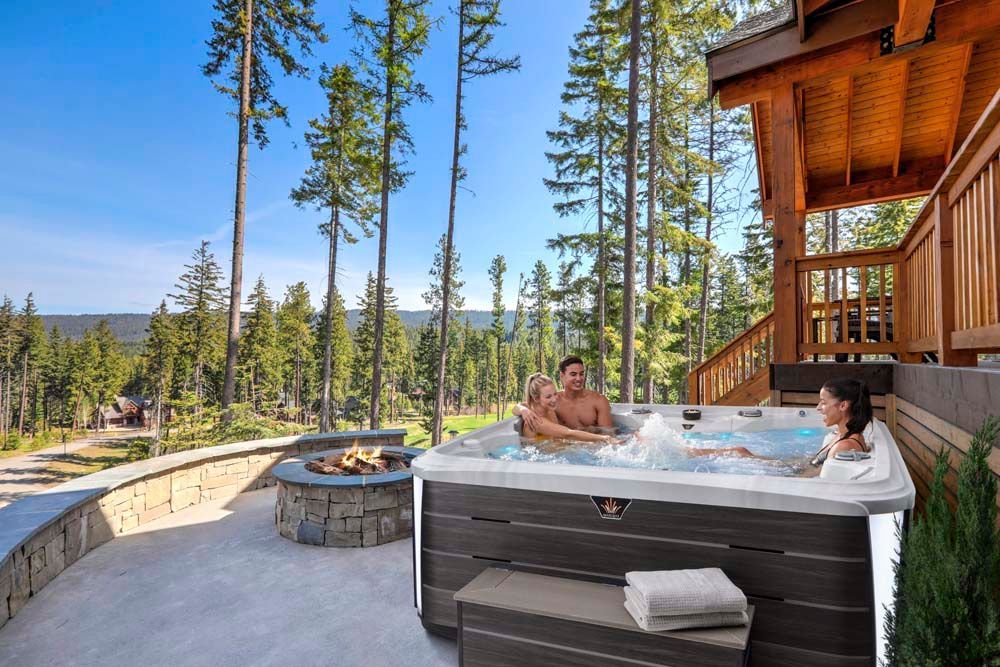 A man and a woman are sitting in a hot tub on a deck.