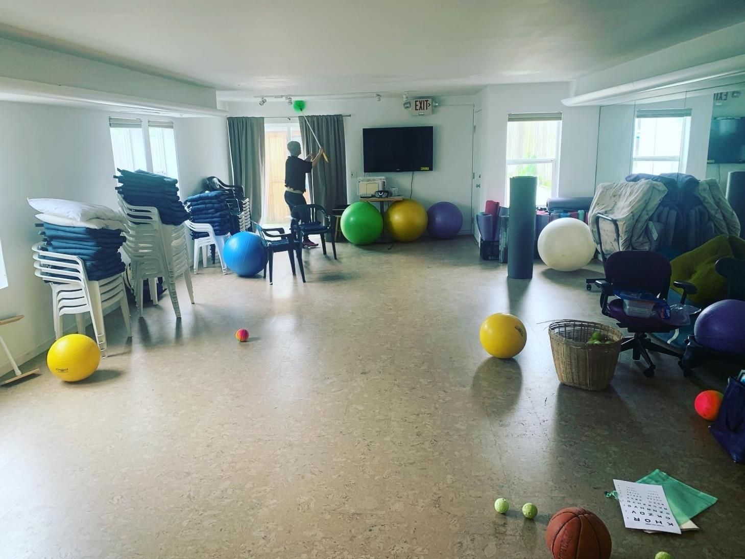 A large room filled with lots of exercise balls and chairs.