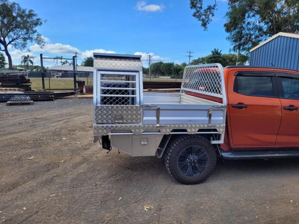 A Red Truck With a Tray on the Back is Parked in a Dirt Lot — LM Engineering In Mareeba, QLD