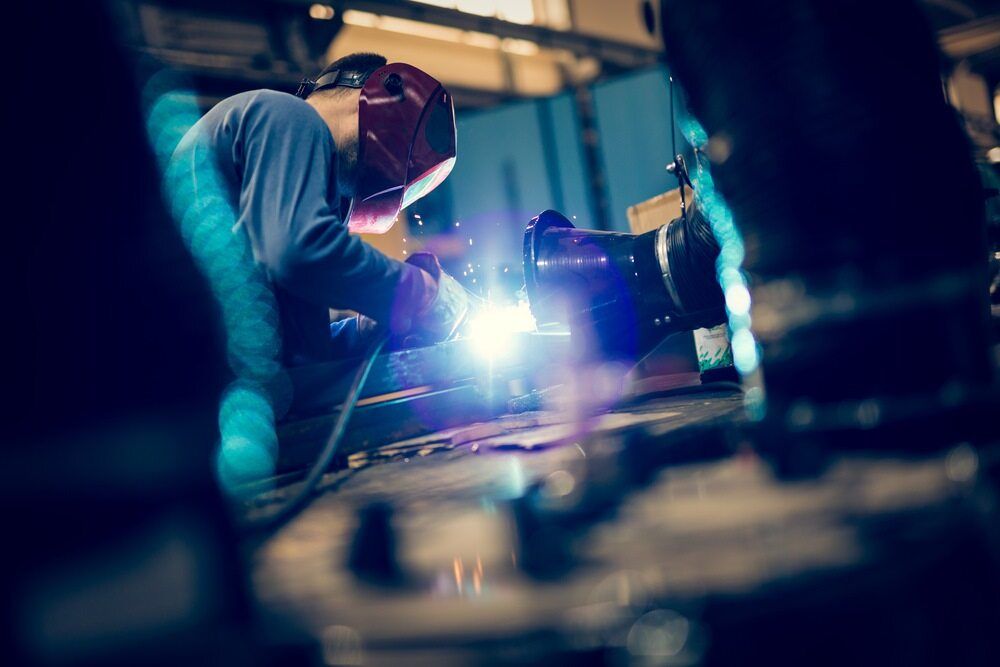 A Man is Welding a Piece of Metal in a Factory — LM Engineering In Mareeba, QLD