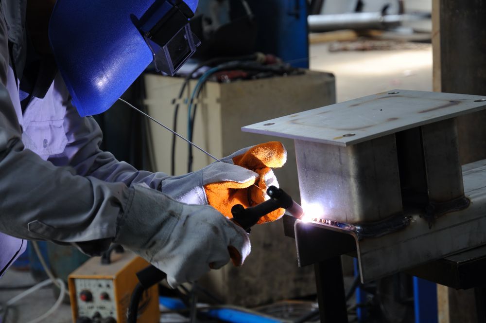 A Man is Welding a Piece of Metal in a Factory — LM Engineering In Mareeba, QLD