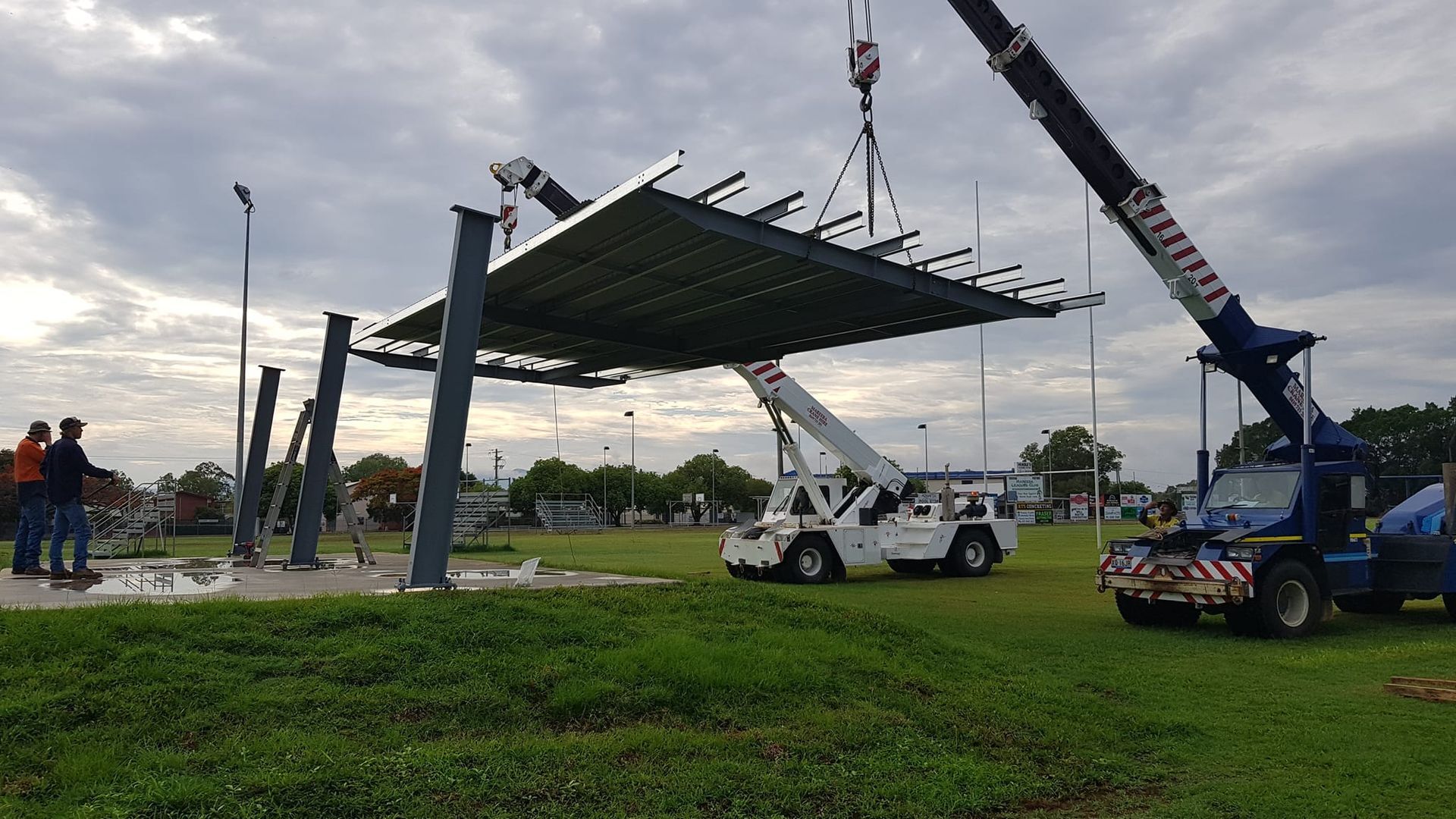 Construction Site: Crane Lifting a Large Canopy Roof — LM Engineering In Atherton Tablelands, QLD