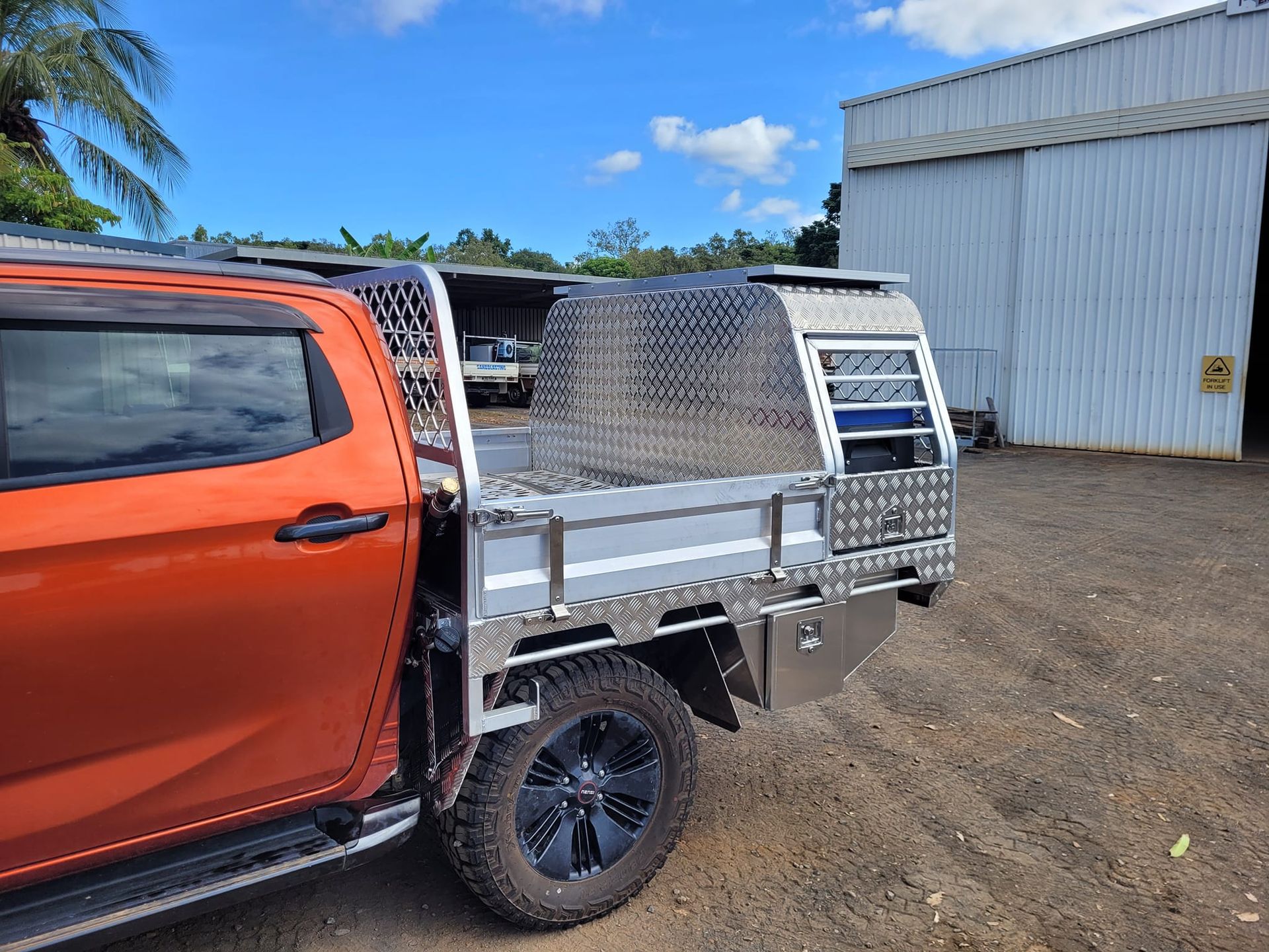 Orange Truck With Silver Canopy Parked Outside — LM Engineering In Atherton Tablelands, QLD