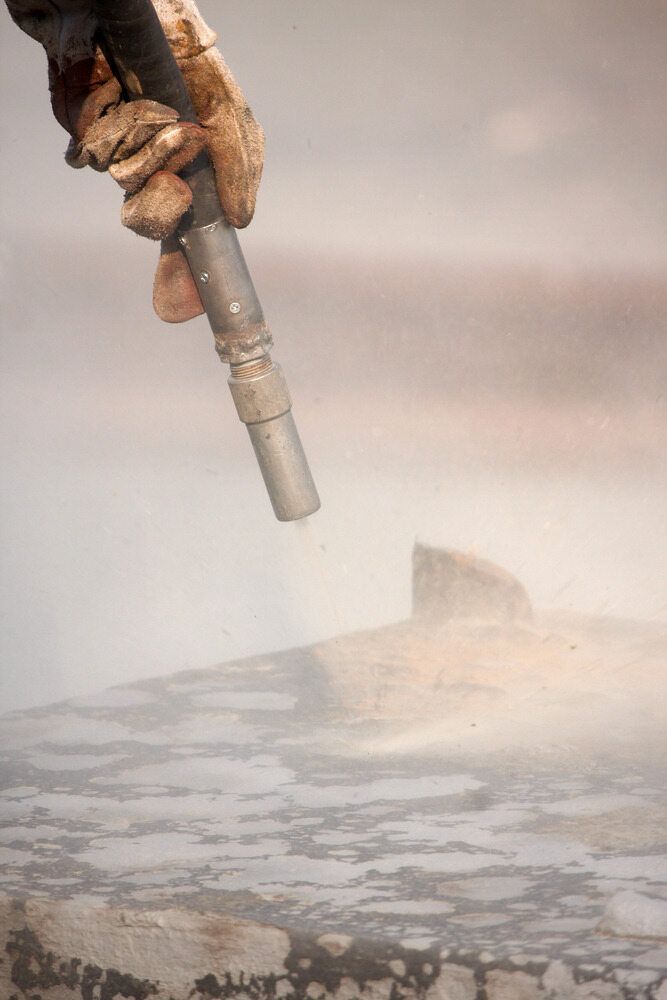 A Person Sandblasting a Rust Metal — LM Engineering In Mareeba, QLD