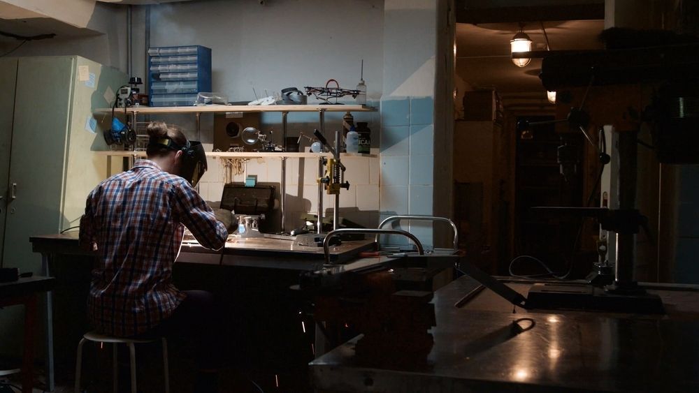 A Man is Sitting at a Table in a Dark Room Wearing Headphones — LM Engineering In Mareeba, QLD