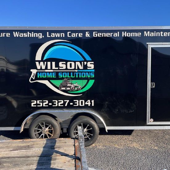 A wilson 's home solutions trailer is parked in a parking lot