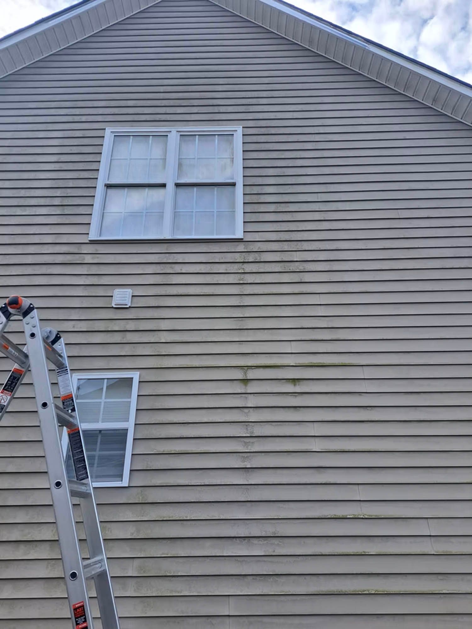 A ladder is leaning against the side of a house.