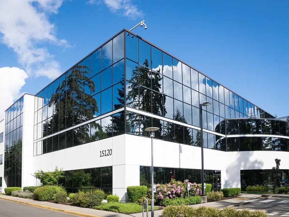A large office building with a lot of windows on a sunny day.