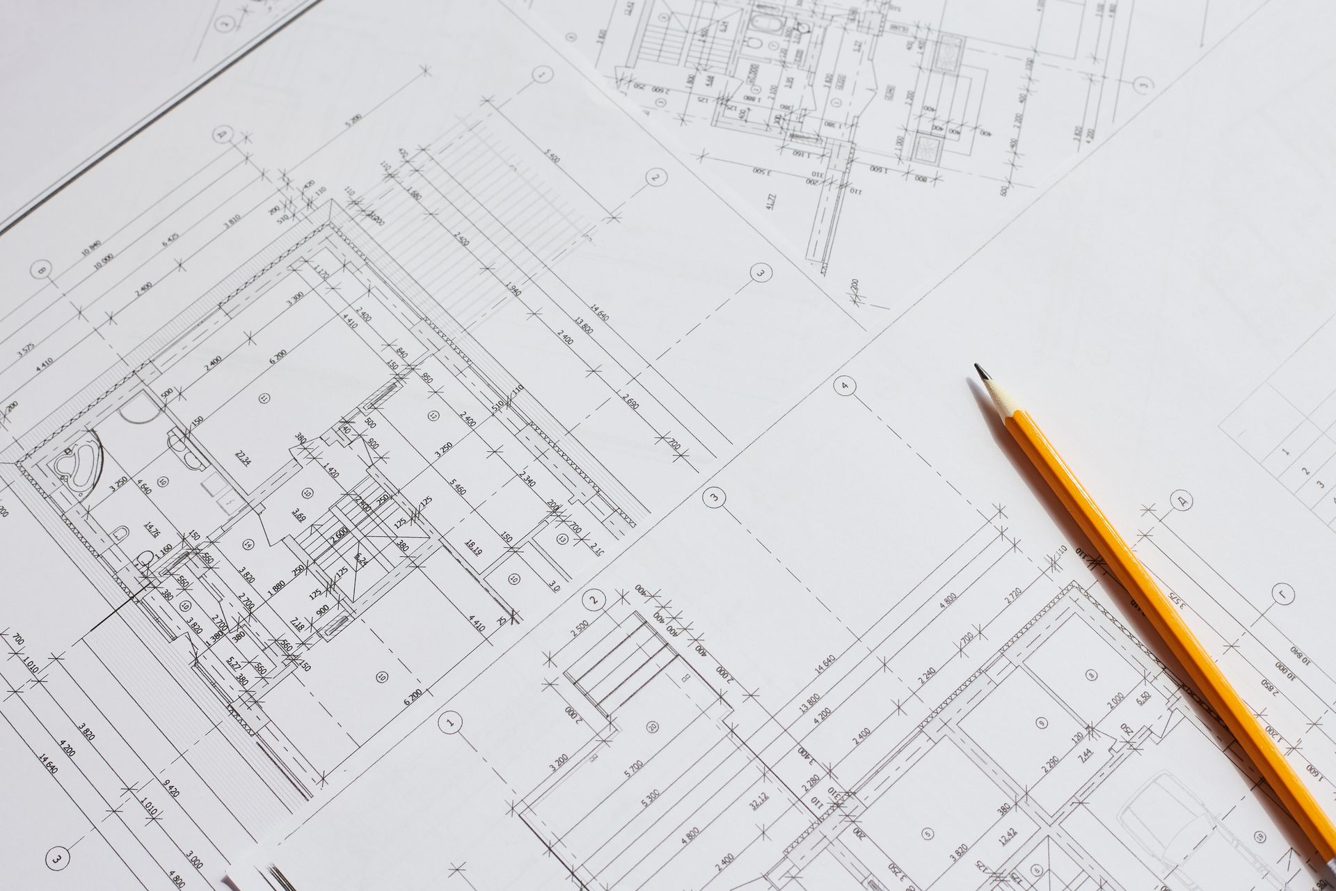 A pencil is sitting on top of a drawing of a building.