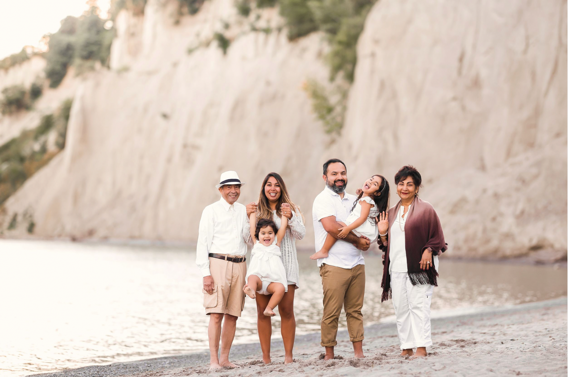 A family is posing for a picture on the beach.