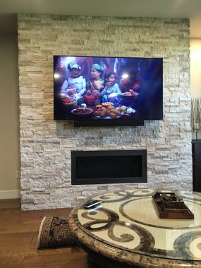 TV over fireplace with soundbar