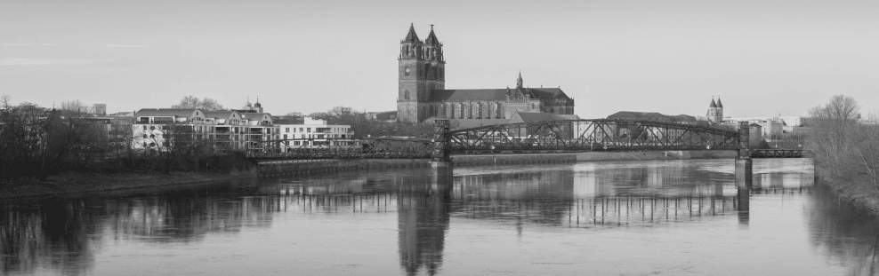 Une photo en noir et blanc d'une ville surplombant un plan d'eau.