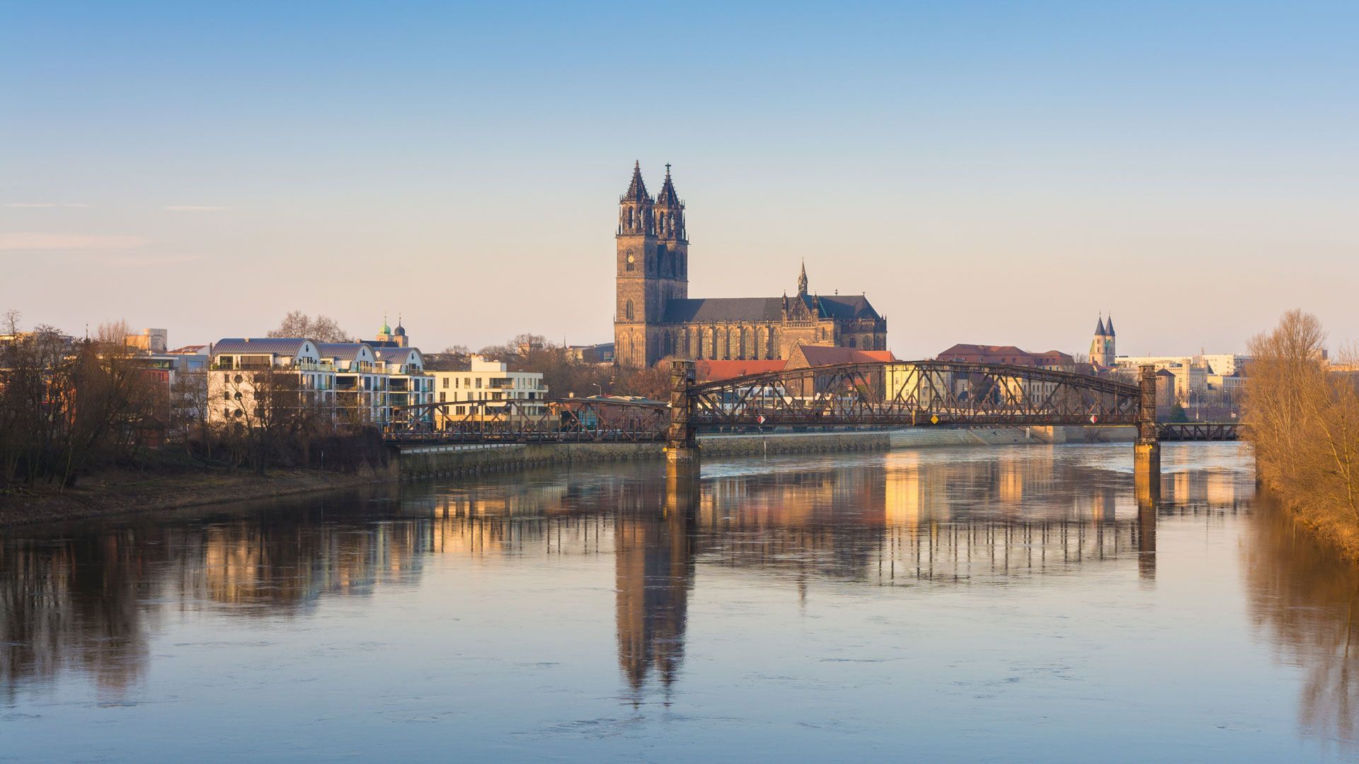 Eine Brücke über einen Fluss mit einer Stadt im Hintergrund.