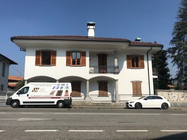 Furgone LM Sverniciature davanti a una casa con finestre in legno