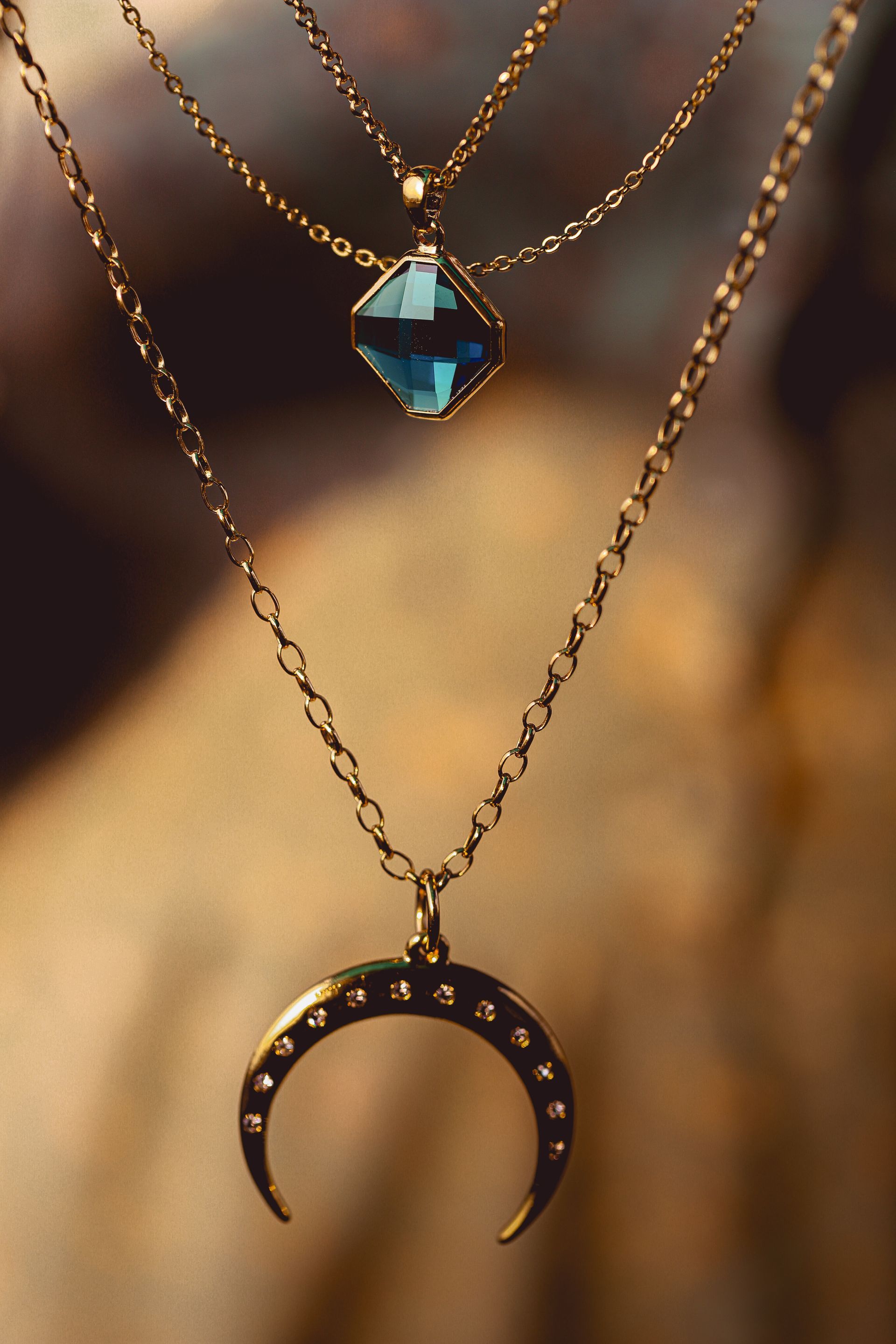 A close up of a necklace with a crescent moon pendant