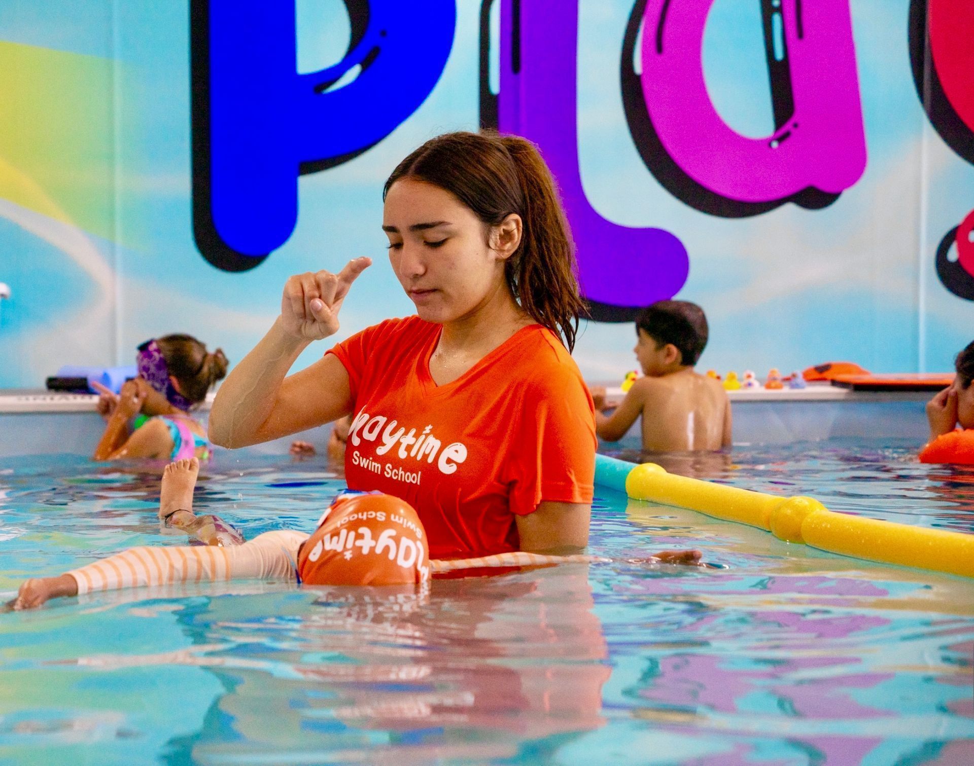 A woman is teaching a child how to swim in a pool.