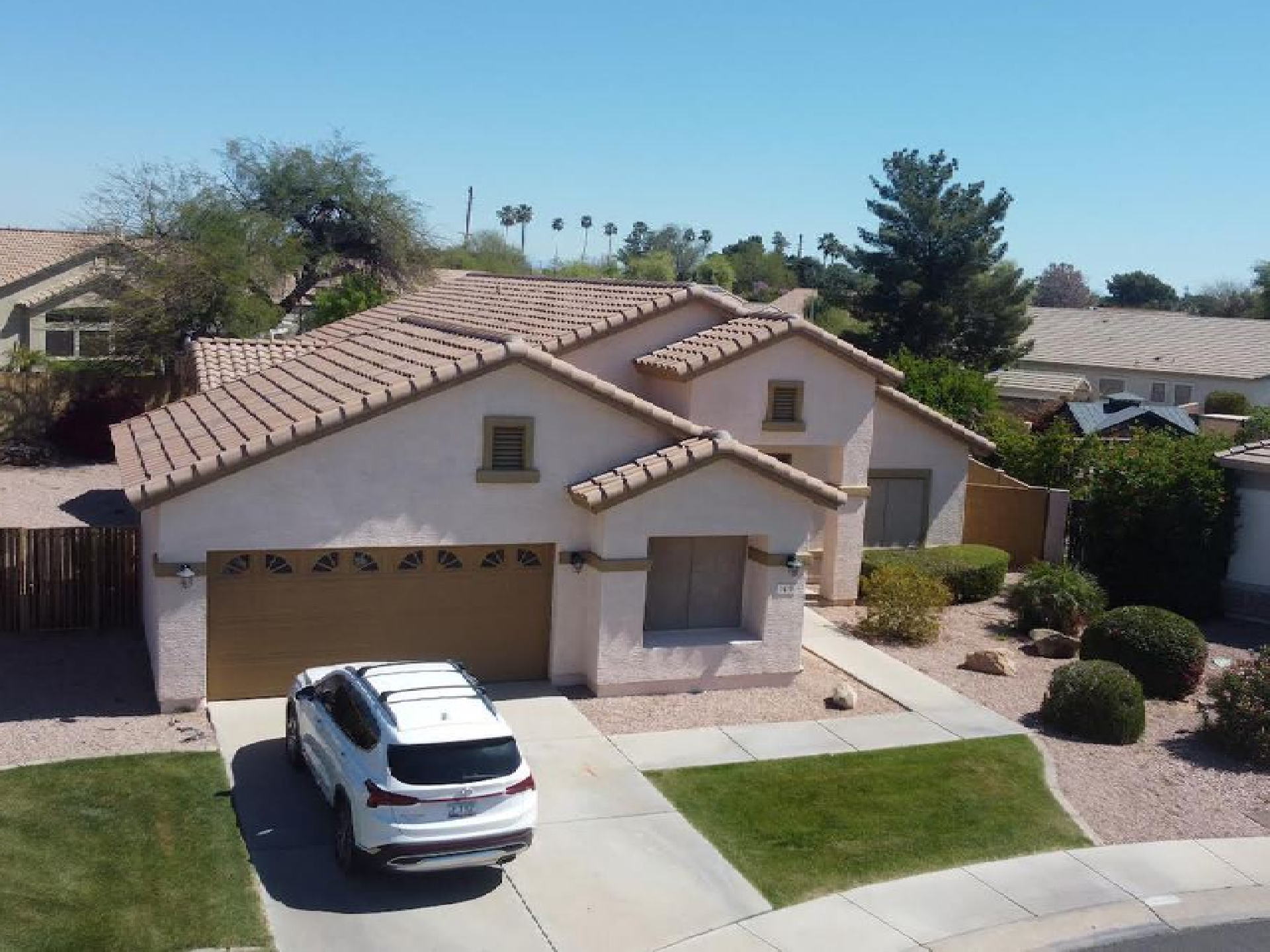 A white suv is parked in front of a house