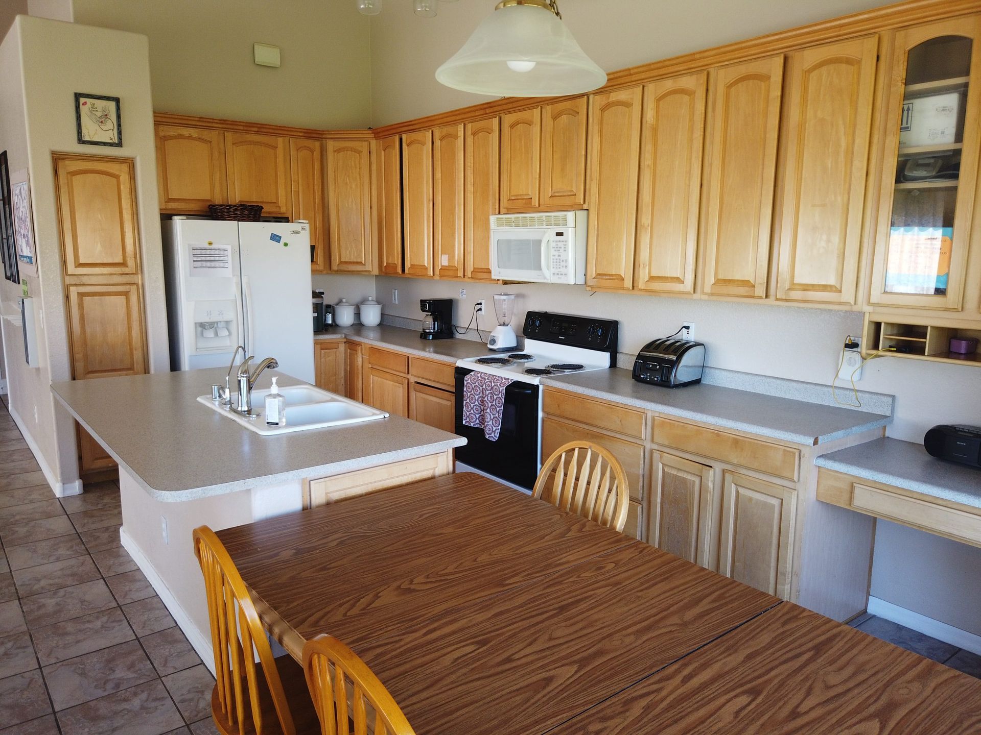 A kitchen with a table and chairs and a refrigerator