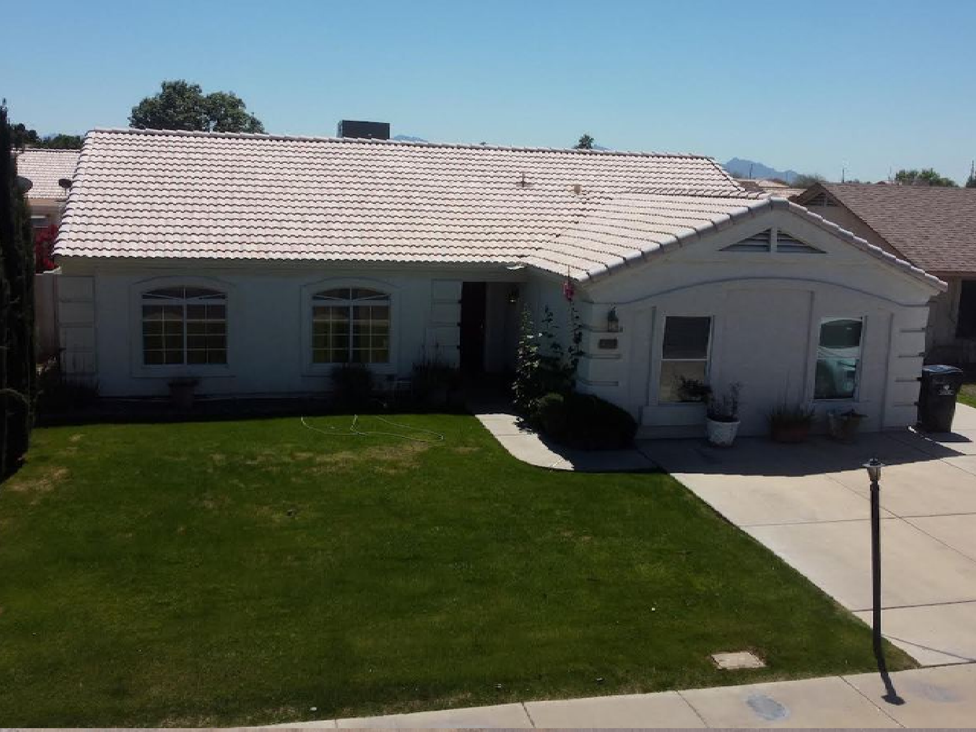 A white house with a roof that has shingles on it