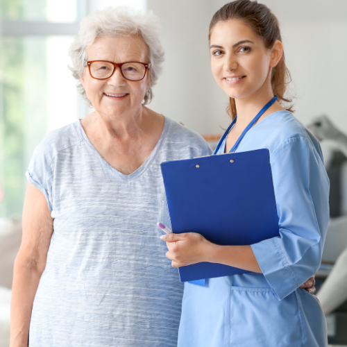 A nurse is standing next to an older woman holding a clipboard.