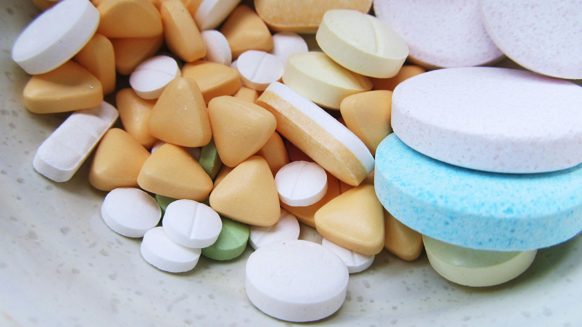 A person is holding a jar of pills in their hand.