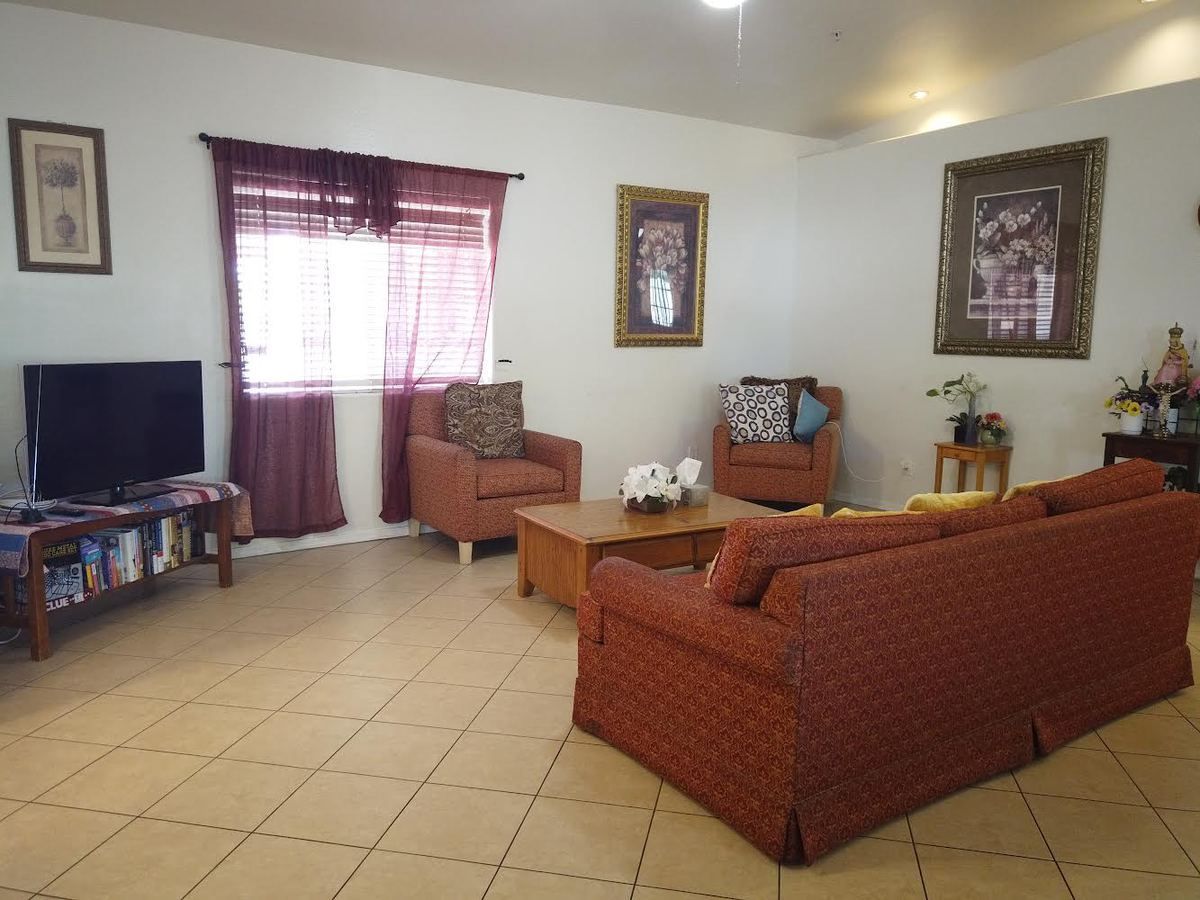 A living room with a couch , chairs and a television