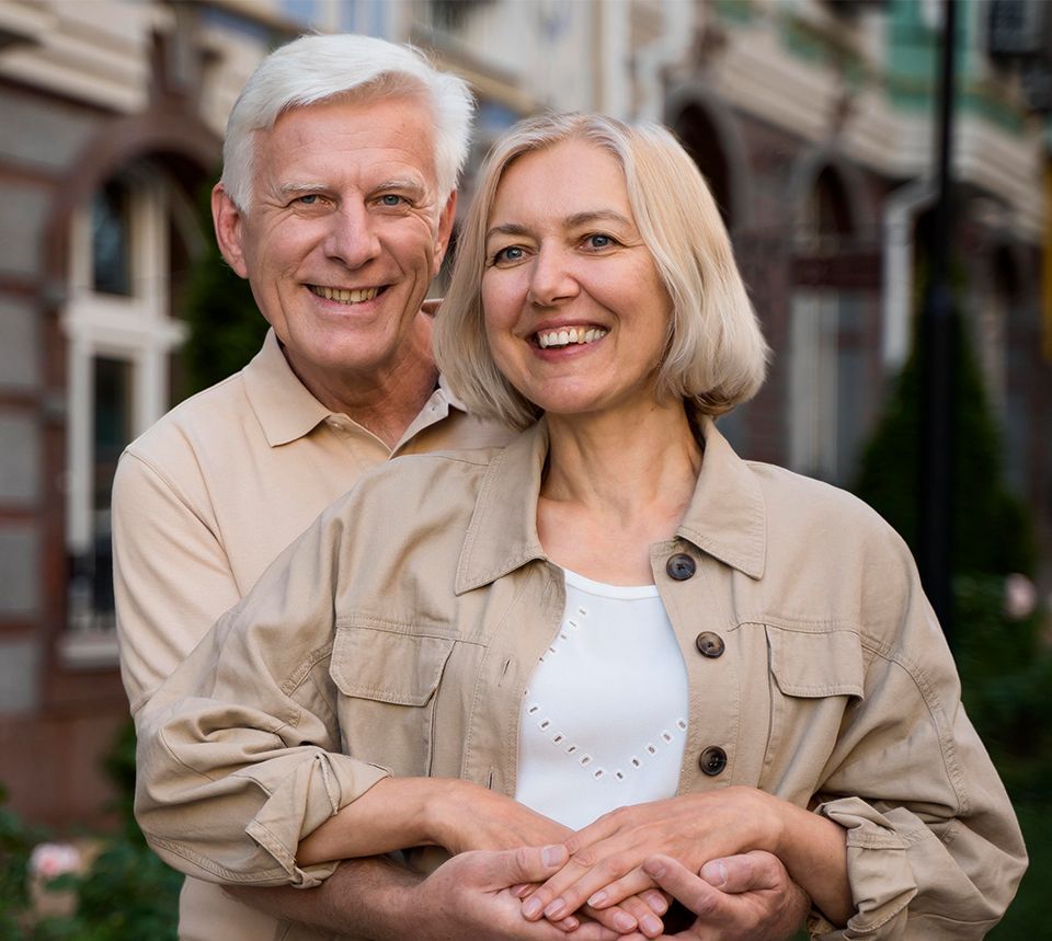 A man and a woman are standing next to each other and smiling for the camera.