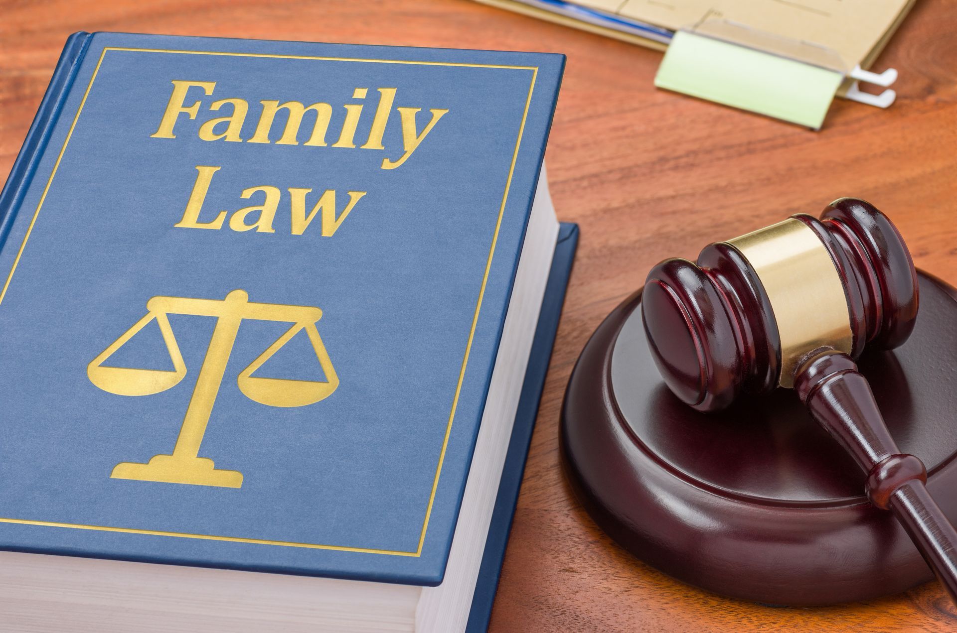 a blue book titled family law sits on a wooden table next to a judge 's gavel .