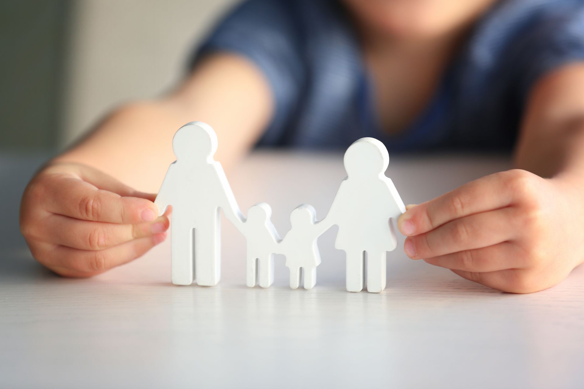 a child is holding a paper cut out of a family .