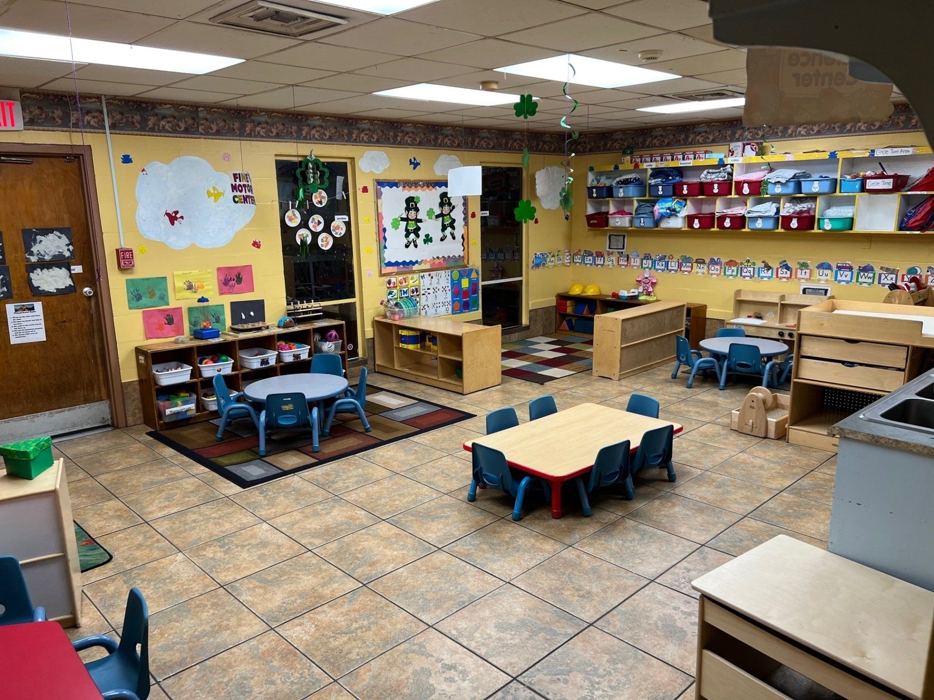 A group of children are laying in a circle on the floor