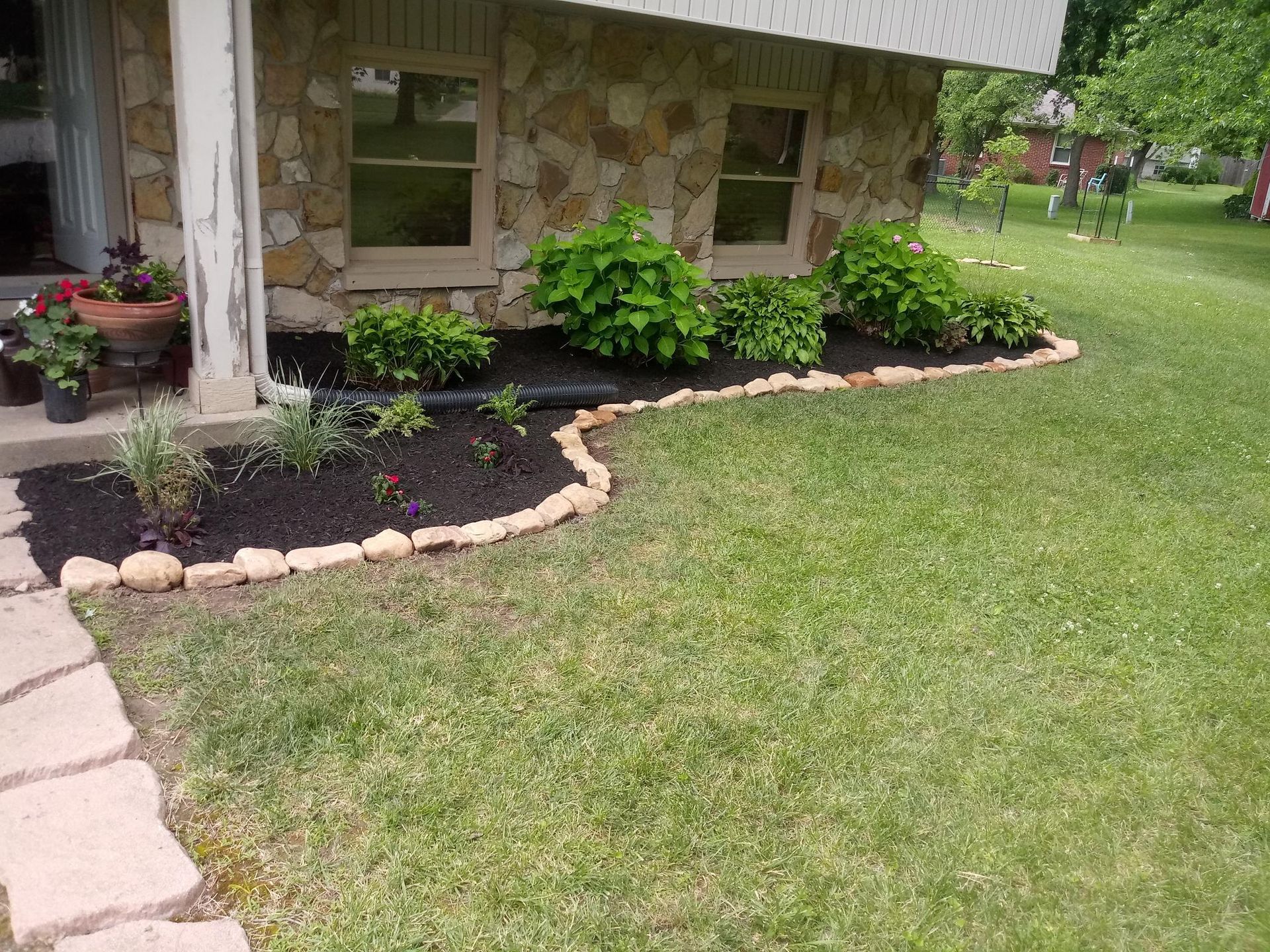 A brick house with a lot of plants in front of it.