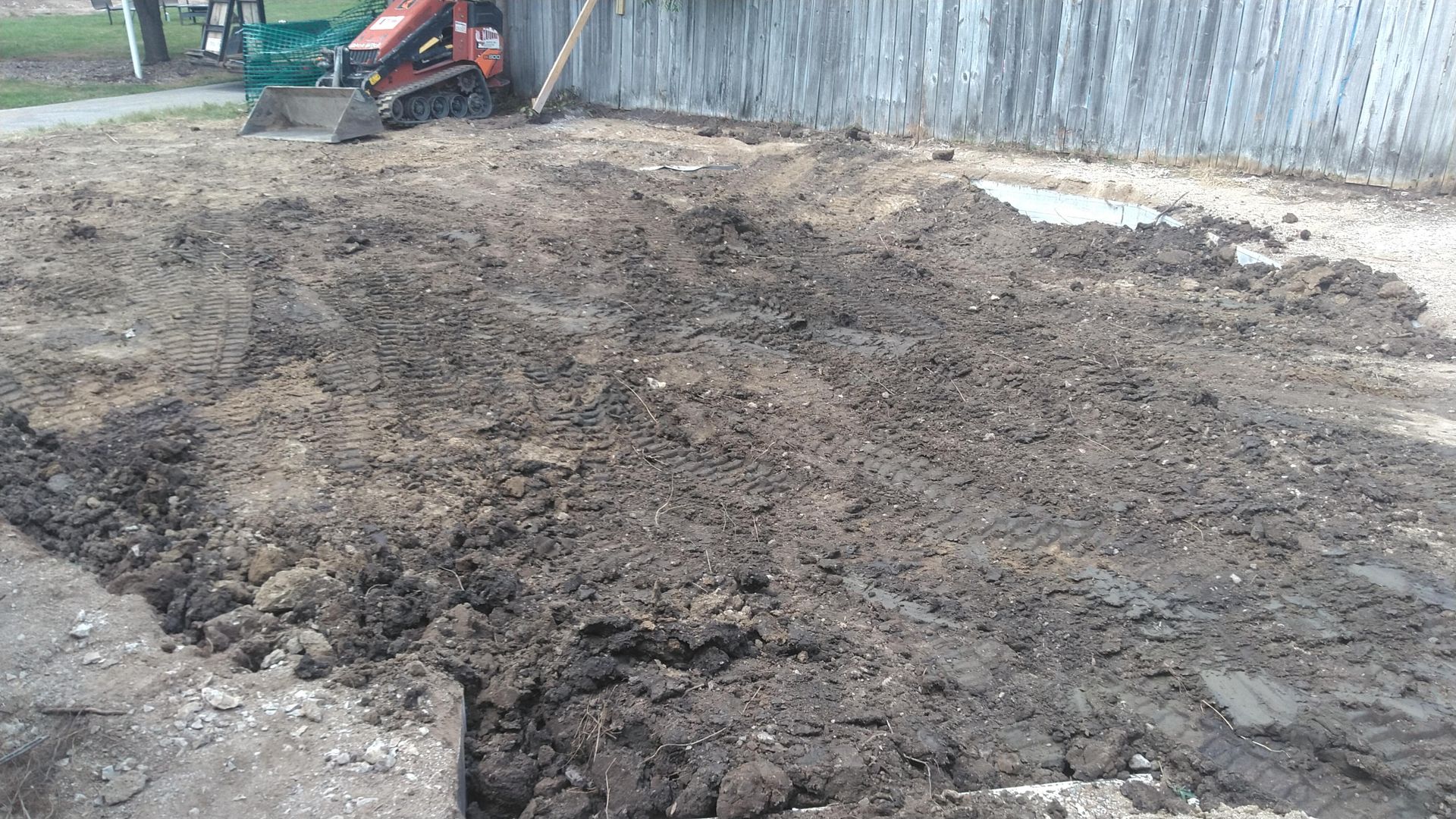 A large pile of dirt is being cleared by a bulldozer.