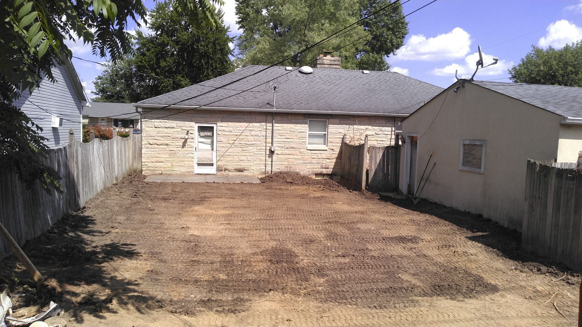 The backyard of a house has a lot of dirt in it
