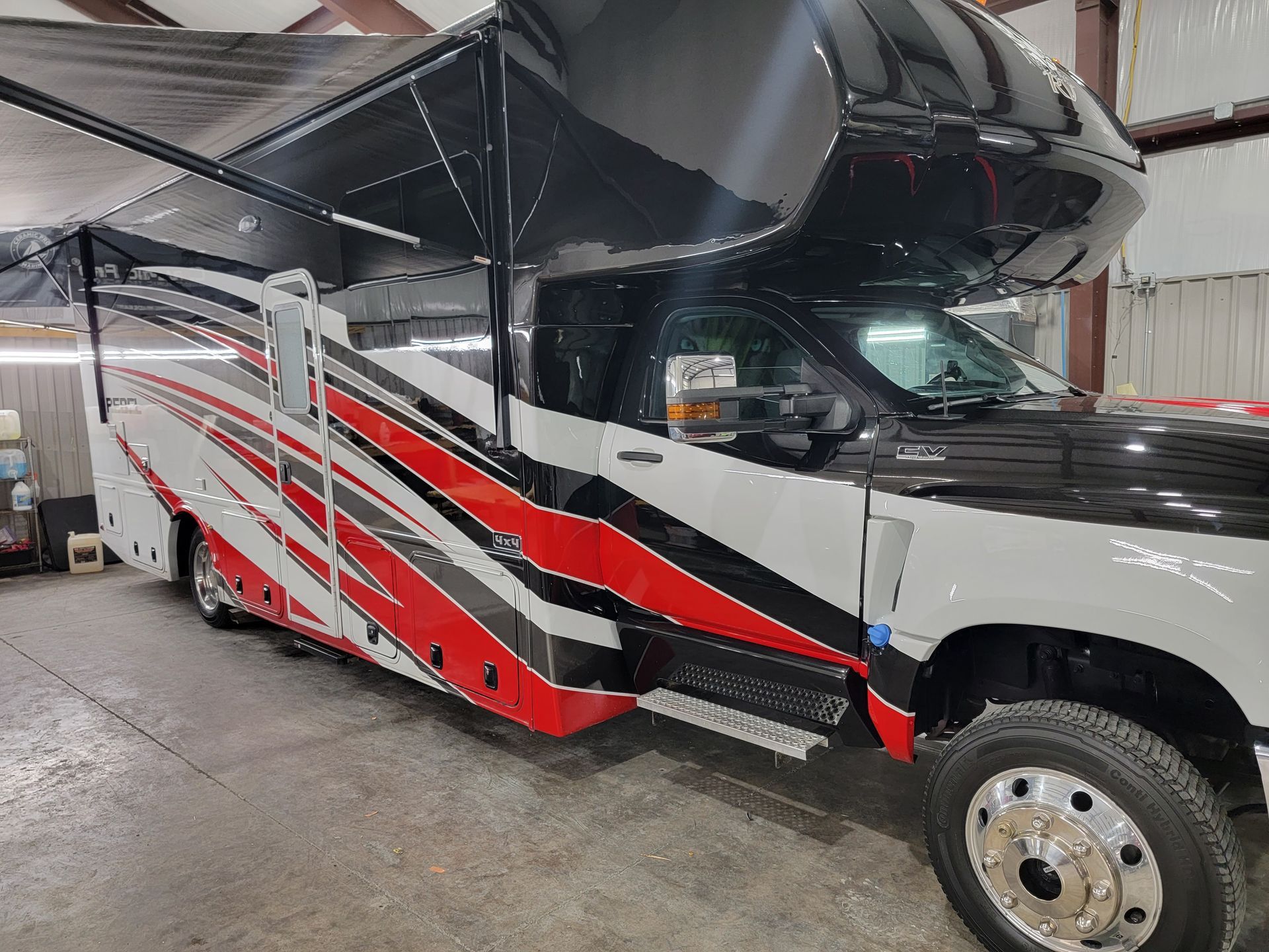 A red and white rv is parked in a garage.