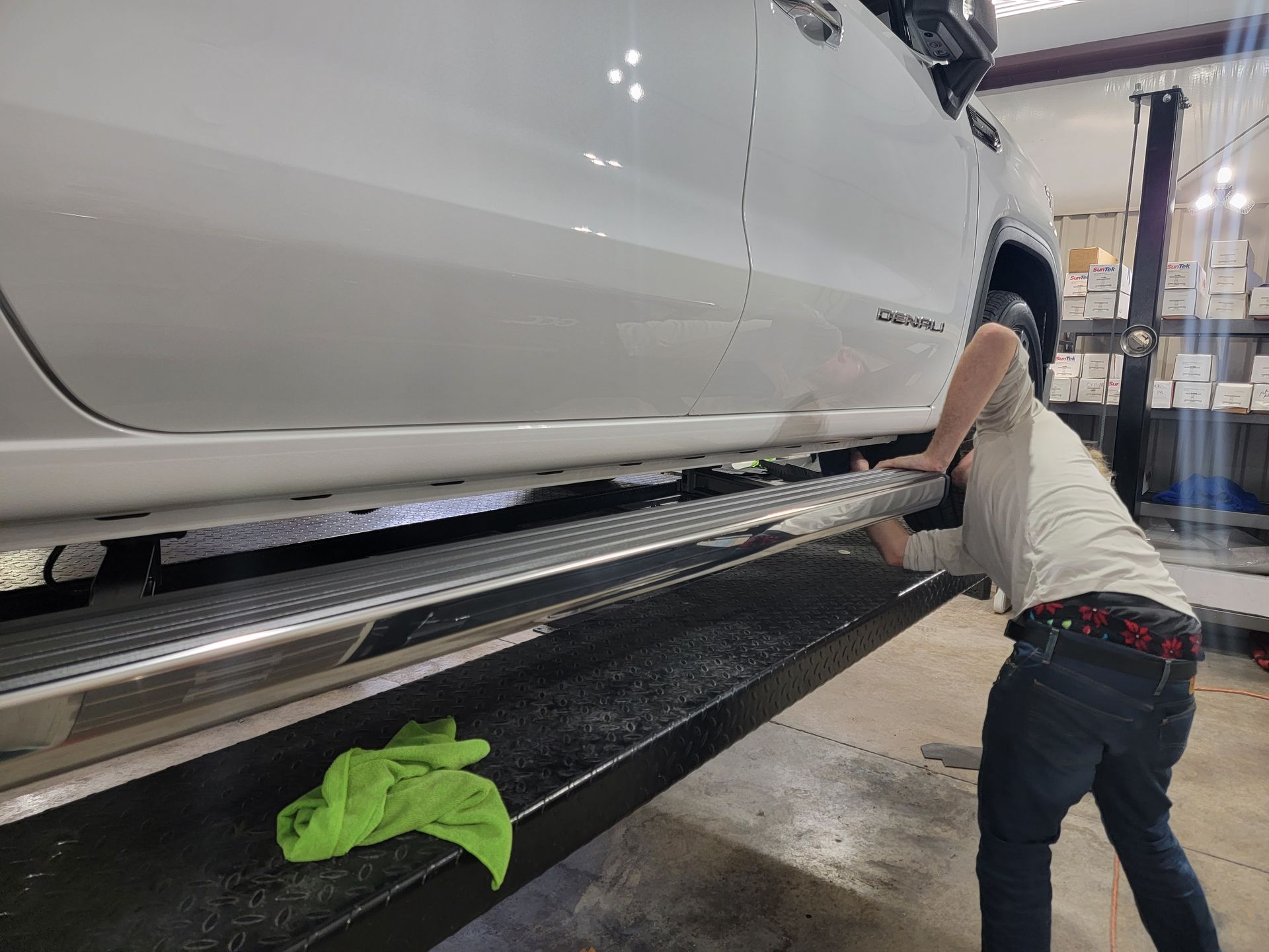 A man is working on the side of a white truck.