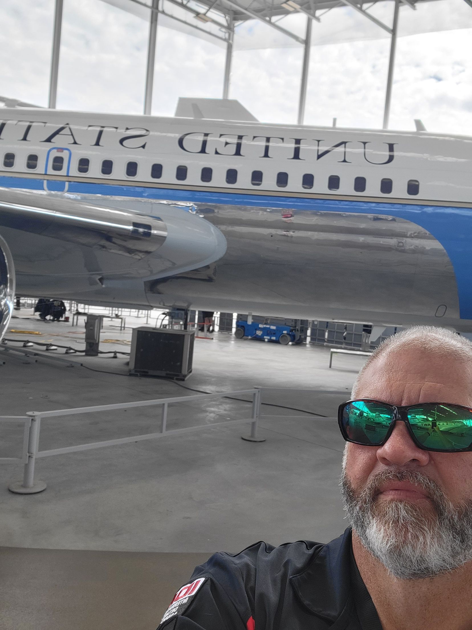 A man taking a selfie in front of a united airlines plane