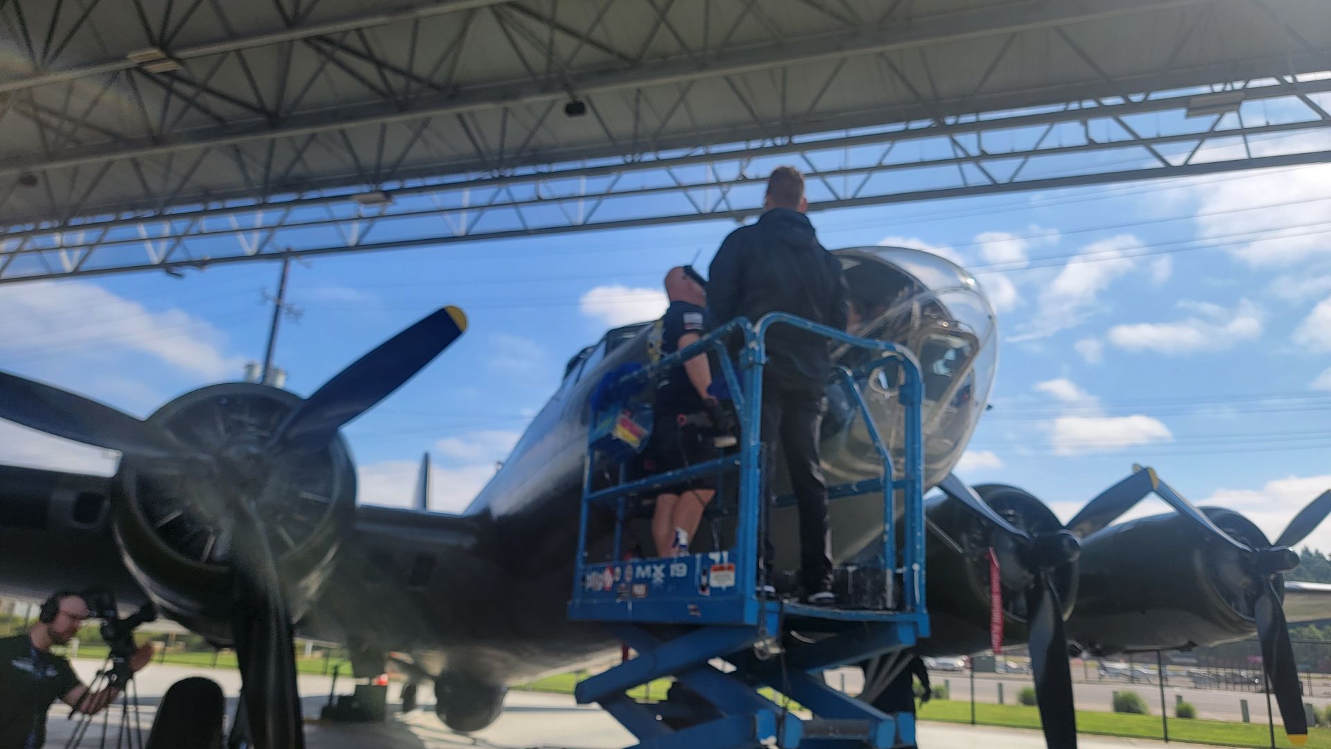 A group of people are working on an airplane in a hangar.