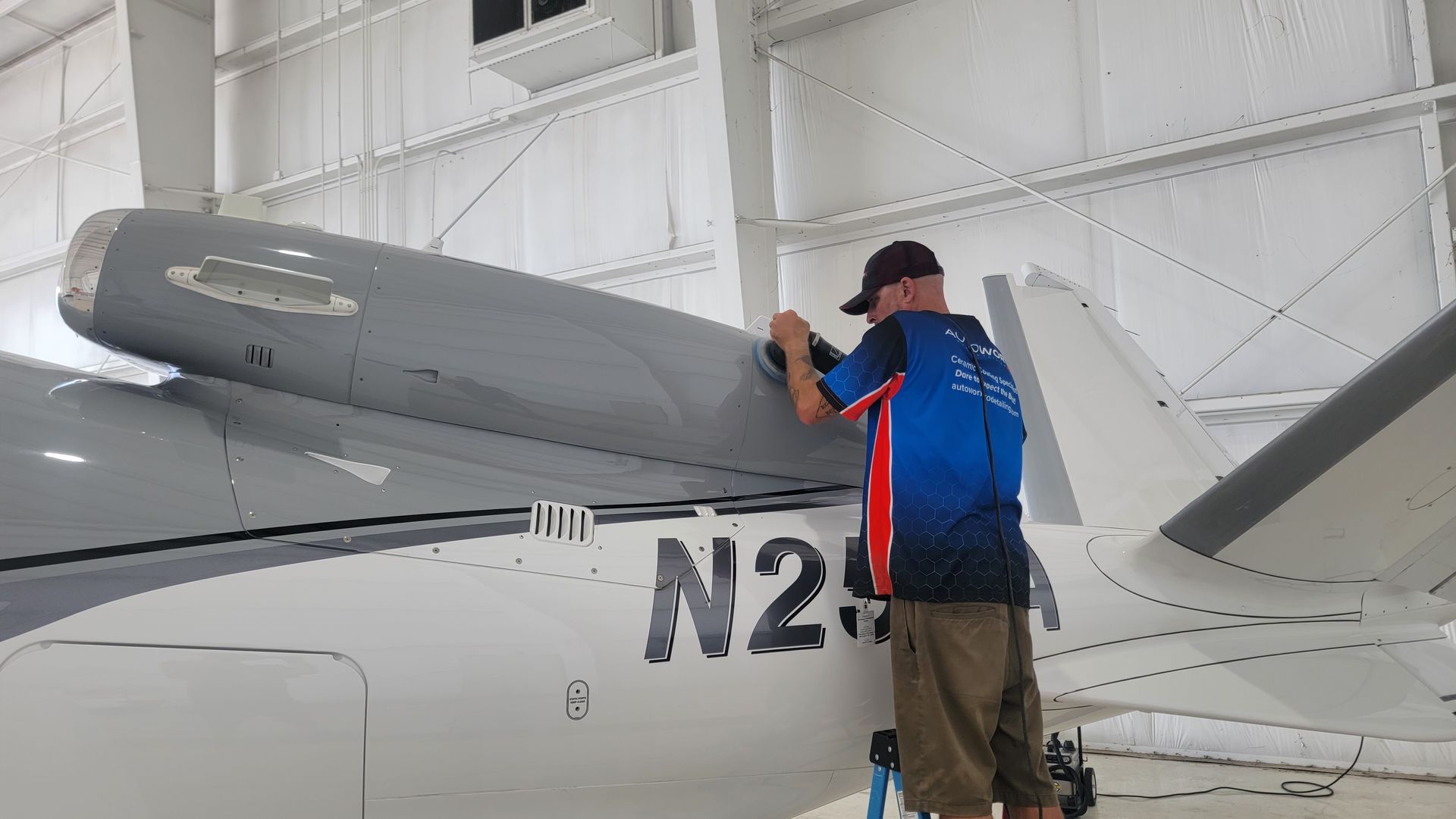 A man is standing next to a plane with the number n2 on it.