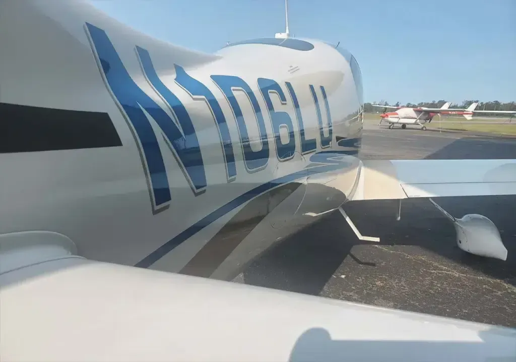 A white and blue airplane with n06lu written on the side