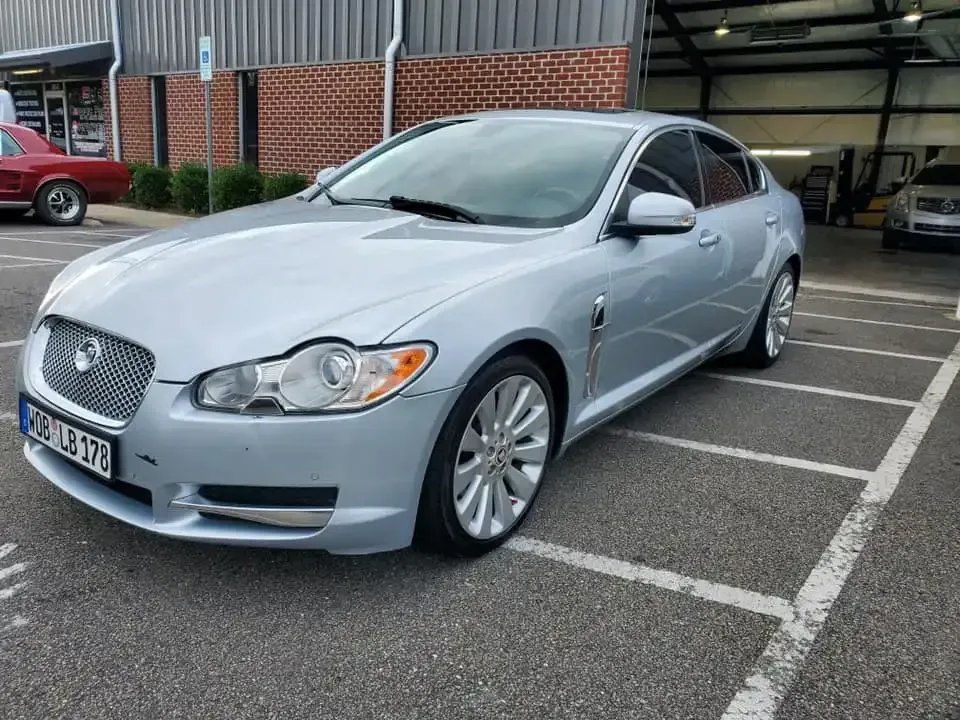 A silver jaguar f type is parked in a parking lot.