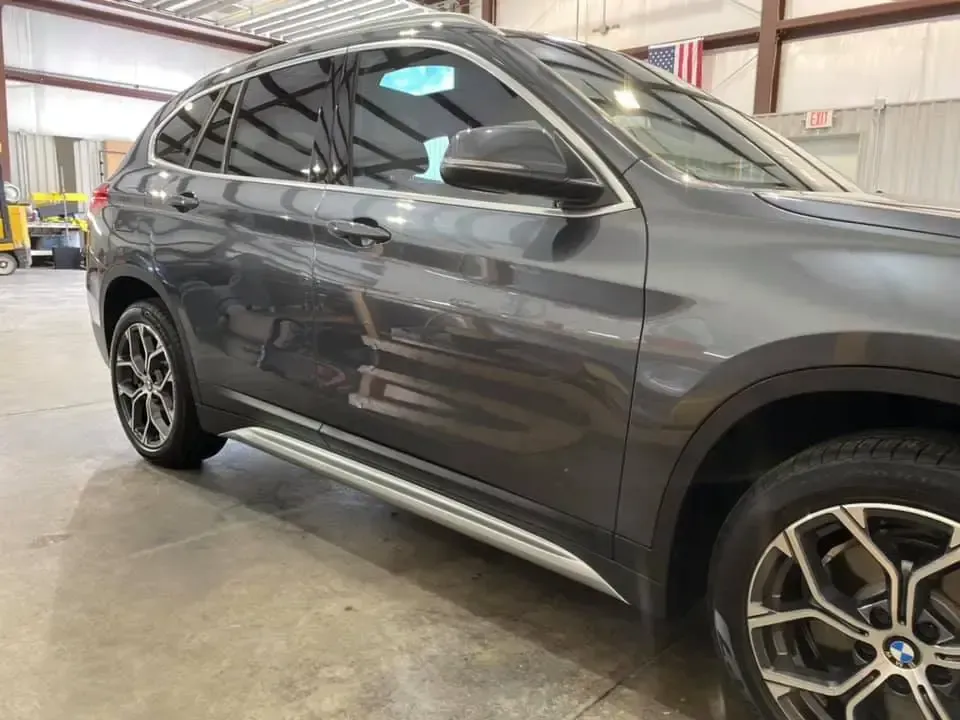 A gray bmw x1 is parked in a garage.