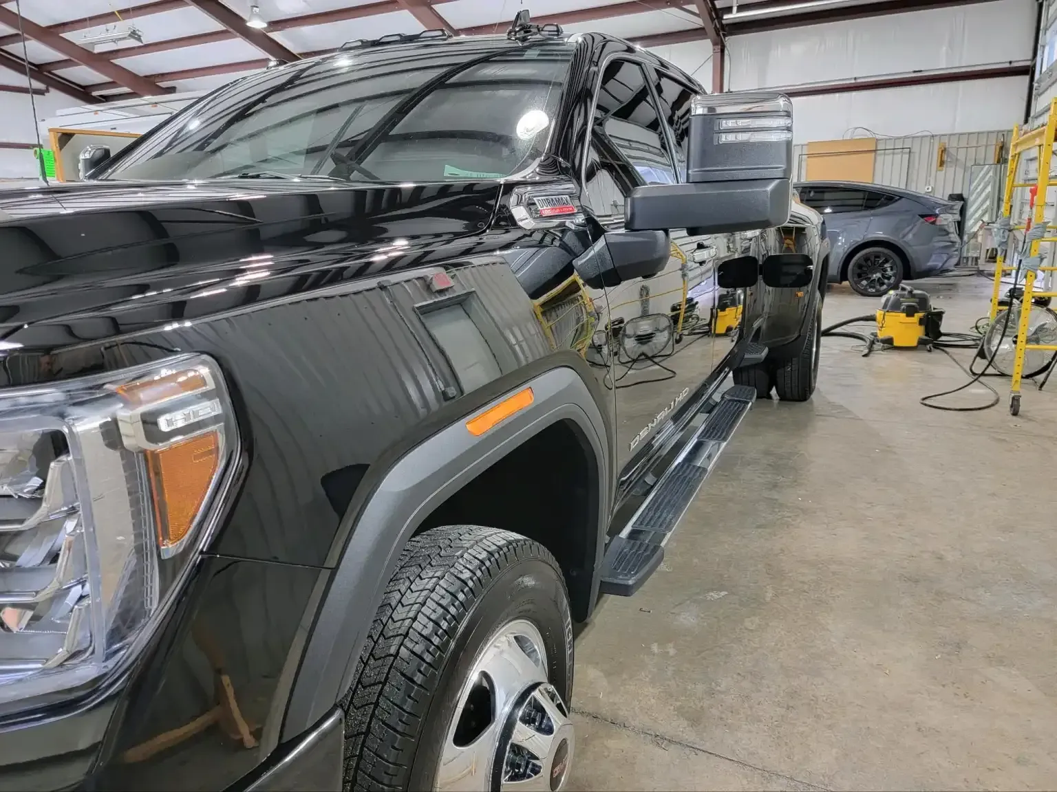 A black truck is parked in a garage.