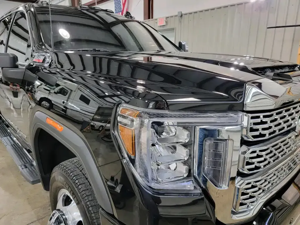 A black truck is parked in a garage in front of a building.