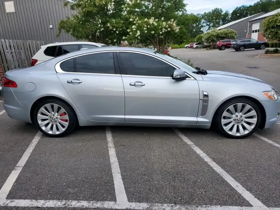 A silver jaguar f type is parked in a parking lot.