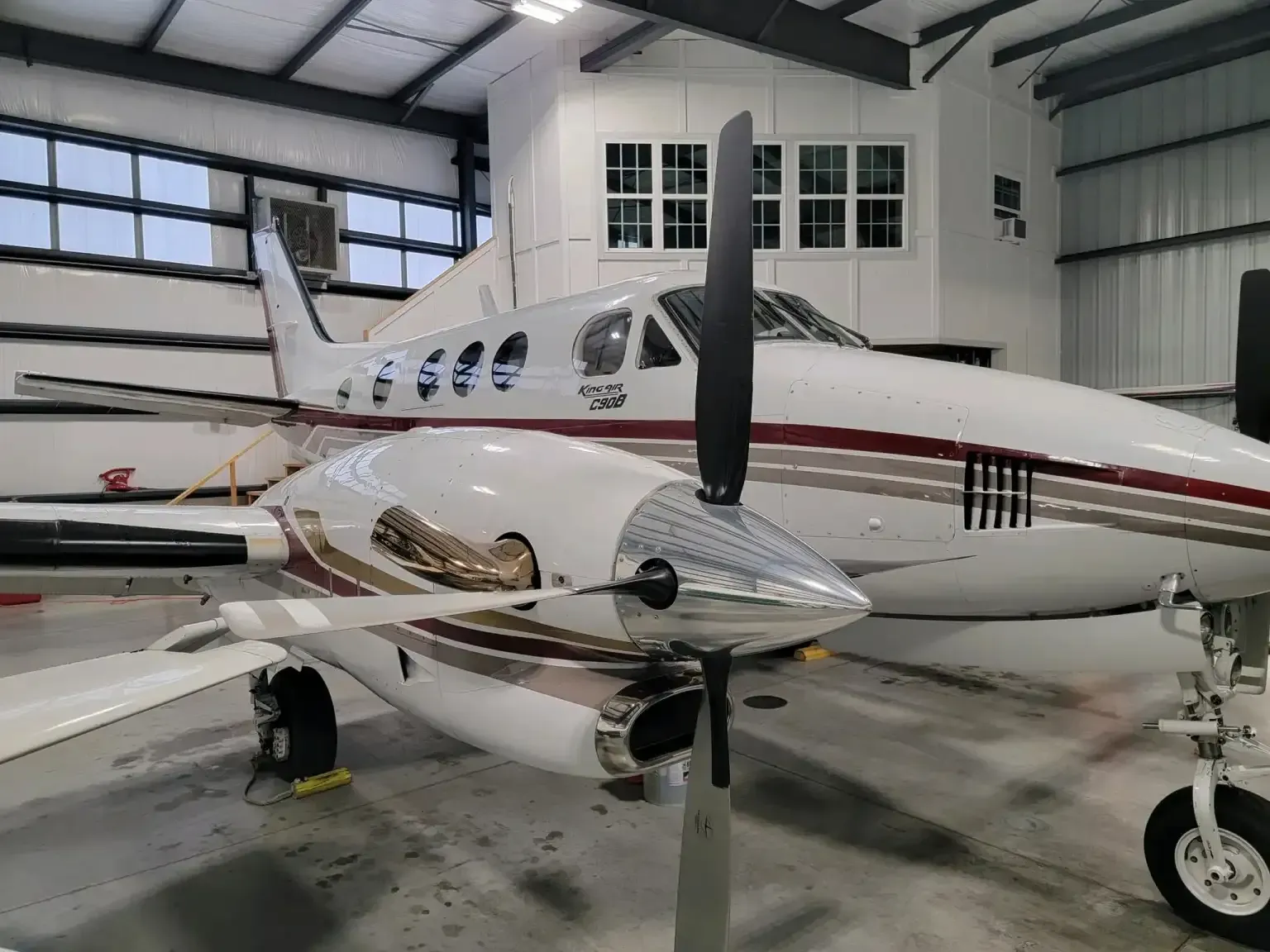 A small propeller plane is parked in a hangar.
