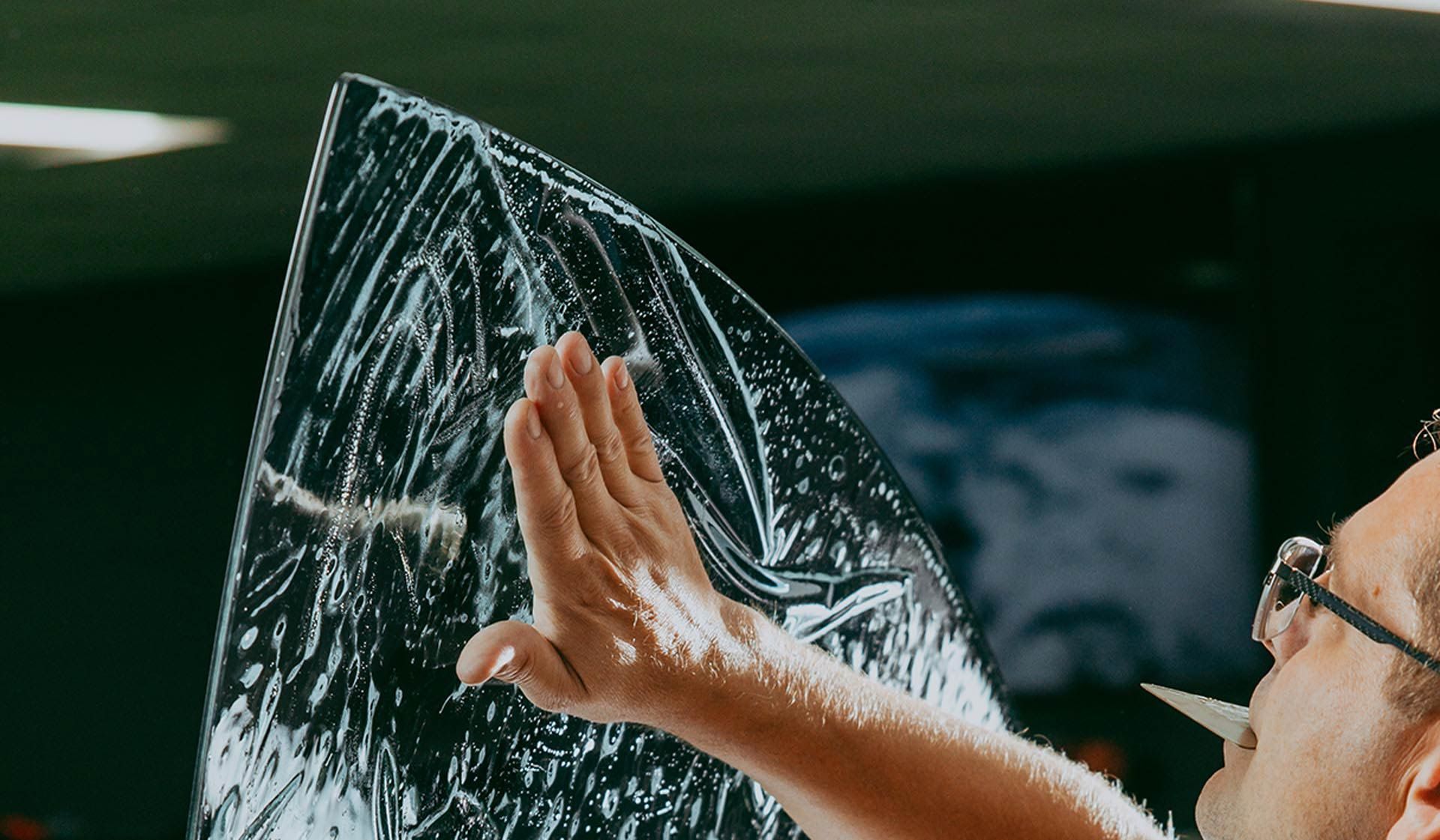 A man is holding a piece of plastic in his hand.