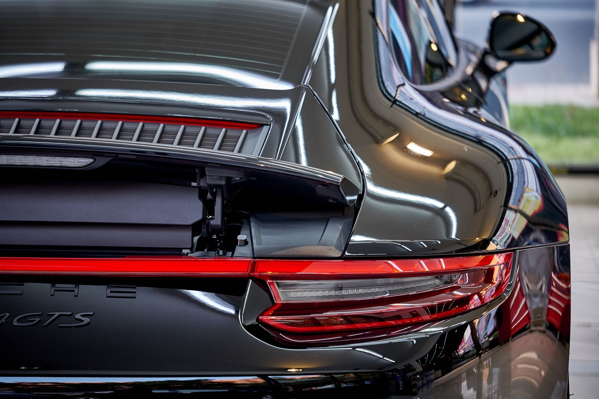 A black porsche 911 turbo s is parked in a parking lot.